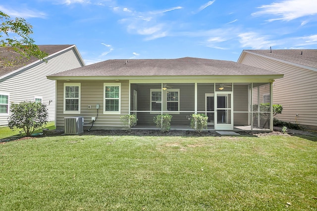 rear view of house with a ceiling fan, a sunroom, roof with shingles, a yard, and central AC