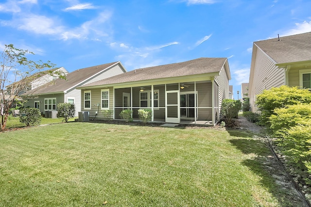 back of property with a sunroom, a lawn, and central air condition unit