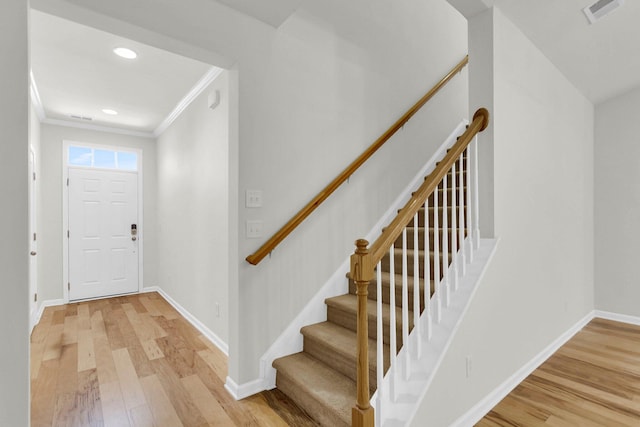 foyer entrance with crown molding, recessed lighting, visible vents, light wood-style flooring, and baseboards