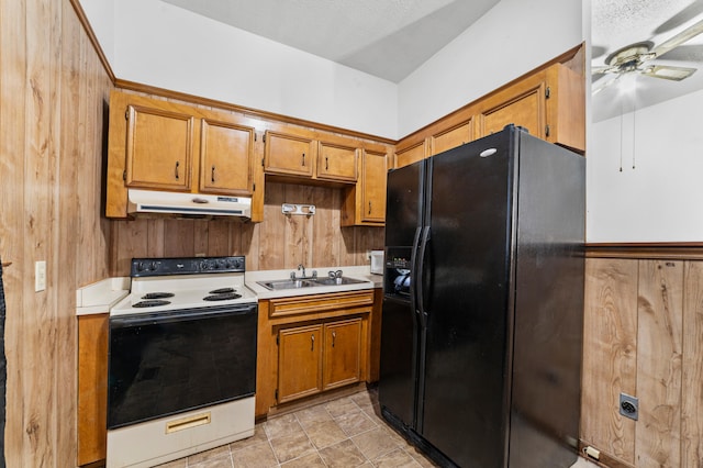 kitchen with black fridge, under cabinet range hood, a sink, range with electric stovetop, and ceiling fan