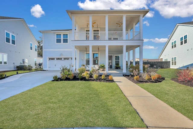 view of front of home with an attached garage, a balcony, a porch, and a front lawn