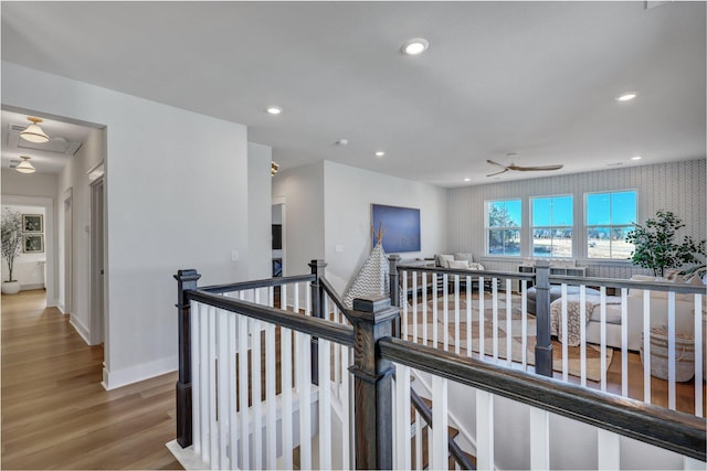 corridor featuring an upstairs landing, recessed lighting, baseboards, and wood finished floors