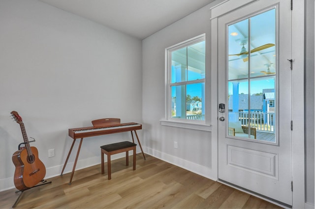 doorway featuring baseboards and light wood-type flooring