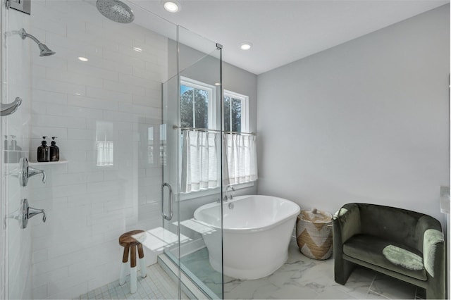 bathroom featuring recessed lighting, marble finish floor, a freestanding bath, and a shower stall