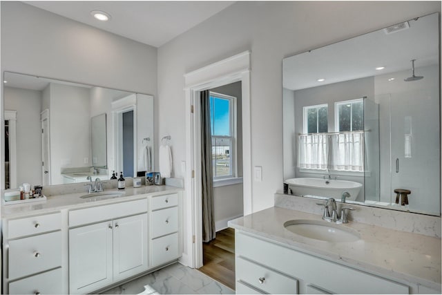 bathroom featuring a shower stall, a healthy amount of sunlight, visible vents, and a sink