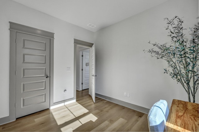 bedroom with light wood-type flooring, visible vents, and baseboards