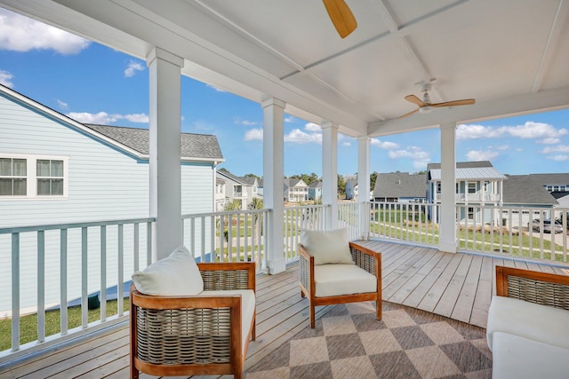 sunroom with a residential view and ceiling fan