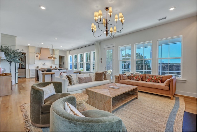 living area with light wood-type flooring, visible vents, recessed lighting, baseboards, and a chandelier