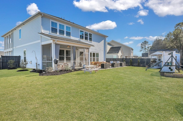 rear view of house with a playground, fence, outdoor lounge area, a yard, and a sunroom