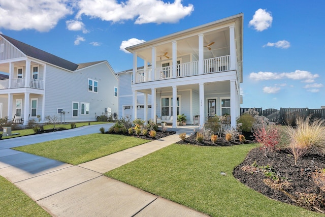 view of front of property featuring driveway, a front lawn, a porch, a balcony, and ceiling fan