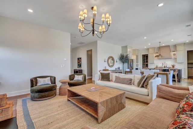 living room with light wood finished floors, visible vents, baseboards, a chandelier, and recessed lighting