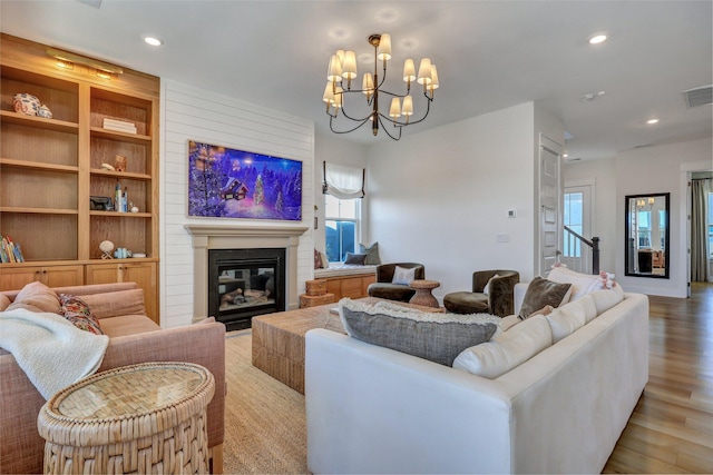 living area featuring recessed lighting, light wood-type flooring, a large fireplace, and visible vents