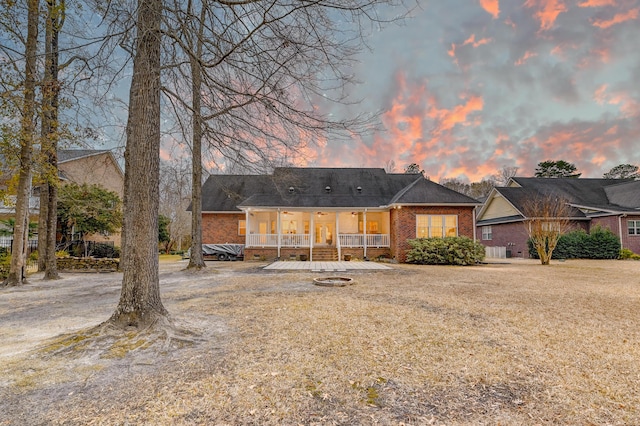 view of front of home with covered porch and brick siding