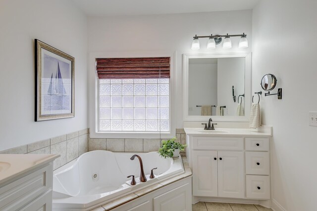 full bath with tile patterned flooring, two vanities, a sink, and a jetted tub