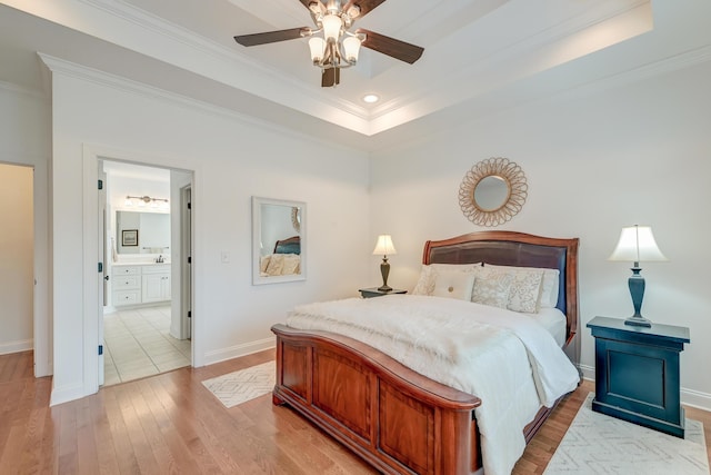 bedroom with light wood-type flooring, baseboards, ornamental molding, and a raised ceiling