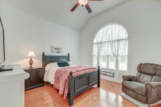 bedroom featuring a ceiling fan, light wood-type flooring, multiple windows, and vaulted ceiling