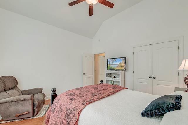 bedroom with high vaulted ceiling, a closet, ceiling fan, and wood finished floors