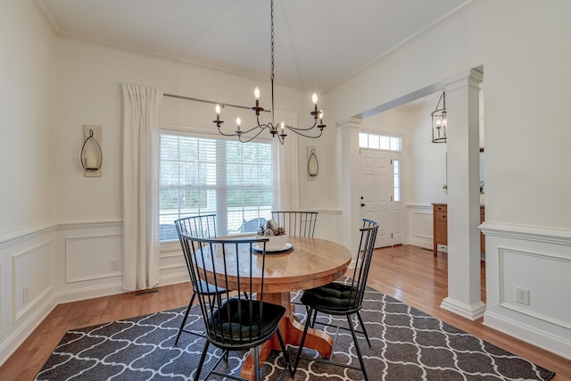 dining area with ornamental molding, a wealth of natural light, and ornate columns