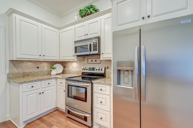 kitchen featuring decorative backsplash, appliances with stainless steel finishes, ornamental molding, white cabinetry, and light stone countertops