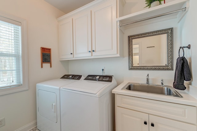 laundry room featuring a wealth of natural light, washing machine and clothes dryer, a sink, and cabinet space