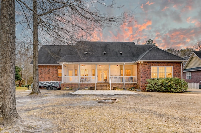 rear view of property with crawl space, ceiling fan, a fire pit, and brick siding