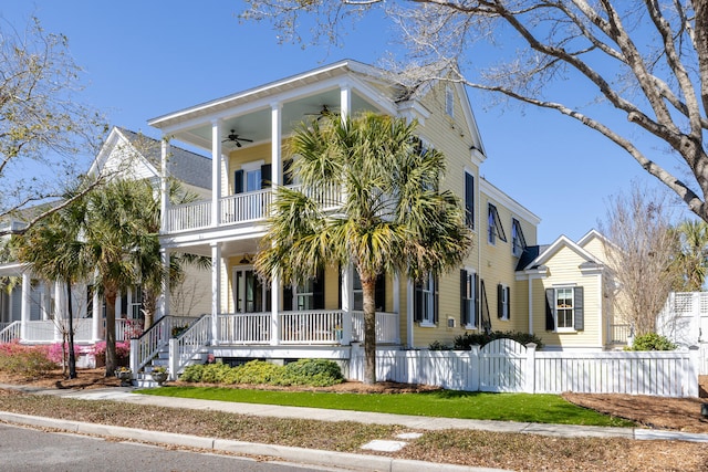 view of front of home with a fenced front yard, a balcony, a porch, and a ceiling fan