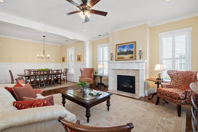 living area with wood finished floors, crown molding, and a decorative wall