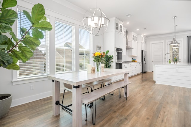 dining area with visible vents, light wood-style flooring, crown molding, baseboards, and a chandelier