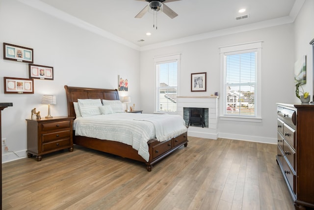 bedroom with visible vents, multiple windows, baseboards, and wood-type flooring