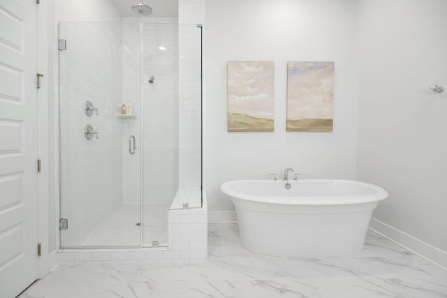 full bath with a freestanding tub, baseboards, marble finish floor, and a stall shower