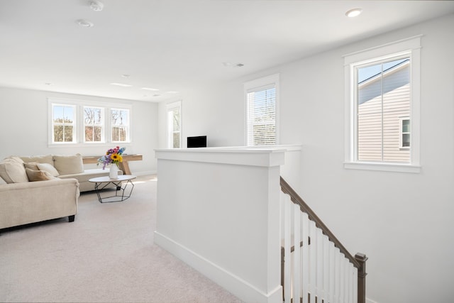 corridor with recessed lighting, an upstairs landing, baseboards, and light carpet