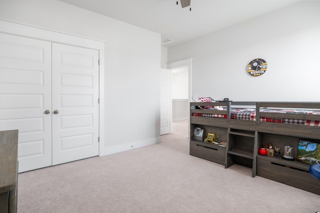 carpeted bedroom with a closet, visible vents, and baseboards