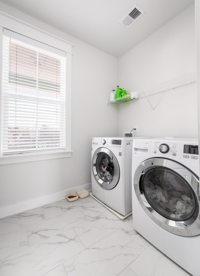 laundry room featuring baseboards, visible vents, washing machine and clothes dryer, laundry area, and marble finish floor