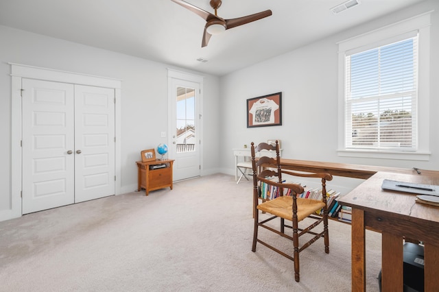 office area featuring visible vents, light colored carpet, and a ceiling fan