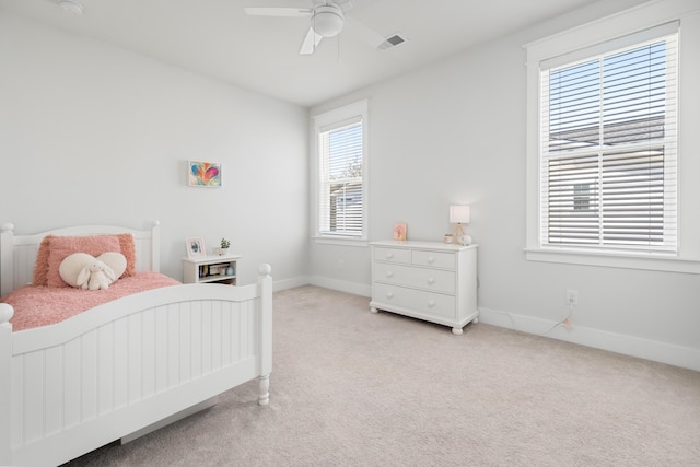 bedroom with visible vents, baseboards, light colored carpet, and a ceiling fan