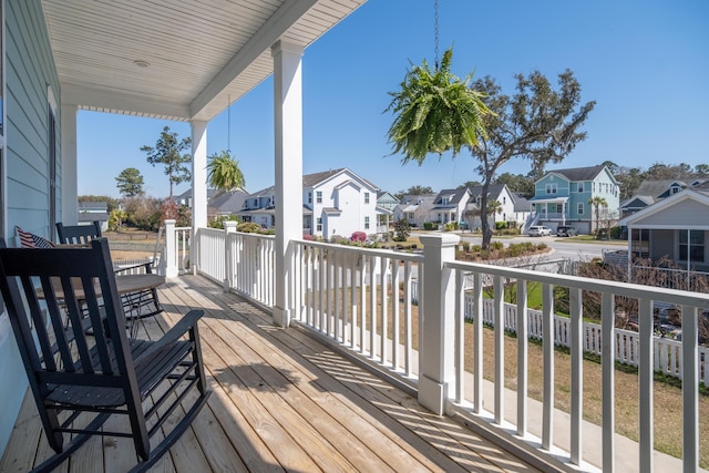 wooden deck featuring covered porch and a residential view