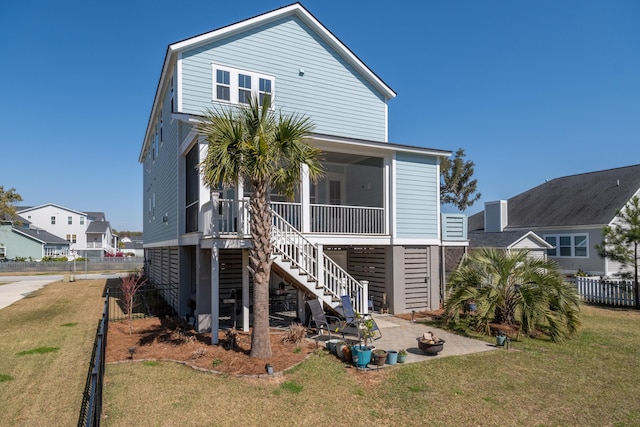 back of property featuring a lawn, fence, stairway, a sunroom, and a patio area