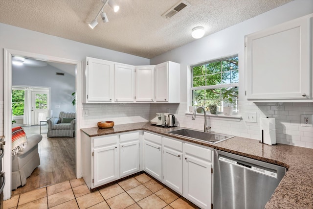 1227 Ocean View Rd, Charleston, SC 29412 - kitchen with stainless steel dishwasher, a sink, plenty of natural light, white cabinets, and a textured ceiling