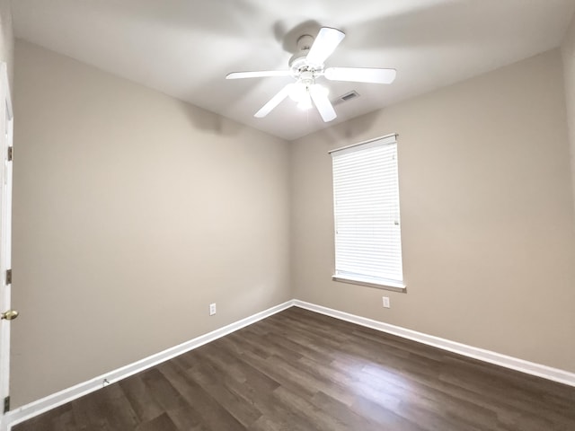 empty room with dark wood-style floors, baseboards, and ceiling fan