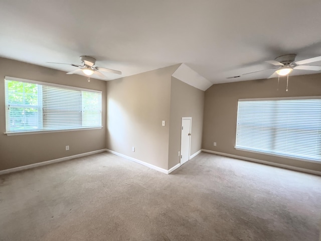 carpeted spare room featuring a ceiling fan, baseboards, and vaulted ceiling