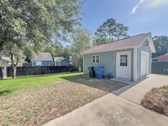 view of yard featuring concrete driveway, an outdoor structure, and a detached garage