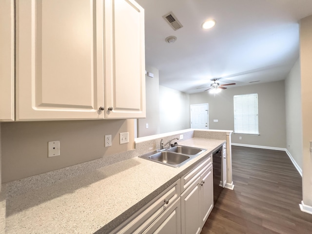 kitchen with a sink, dishwasher, dark wood-style flooring, a ceiling fan, and white cabinets