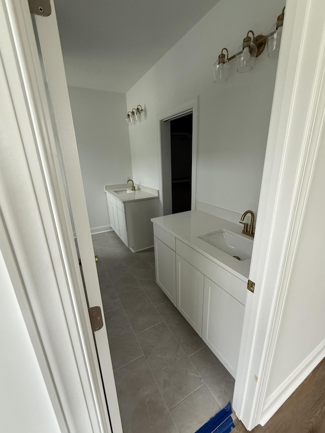 bathroom featuring tile patterned flooring, two vanities, and a sink