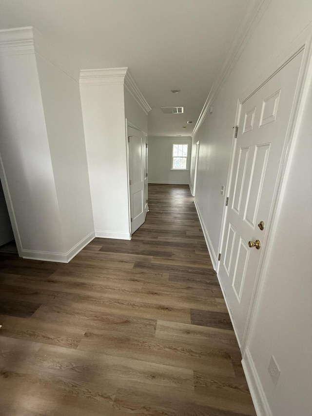 hall featuring baseboards, dark wood-style flooring, and crown molding