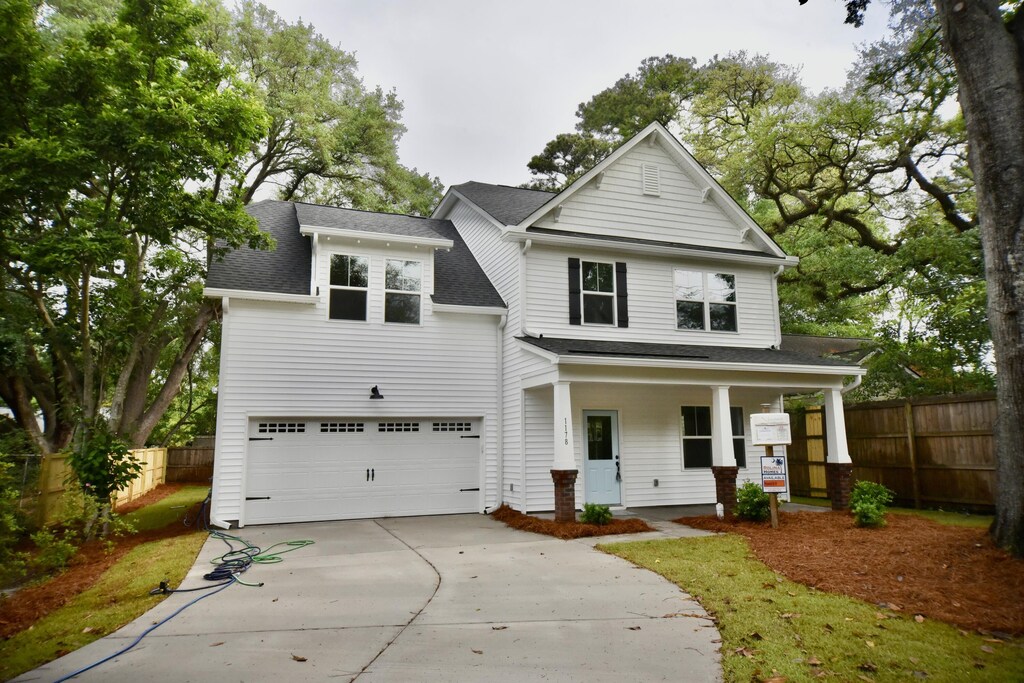 1178 Braddock Ave, North Charleston, SC 29406 - view of front facade with a garage, covered porch, roof with shingles, concrete driveway, and fence
