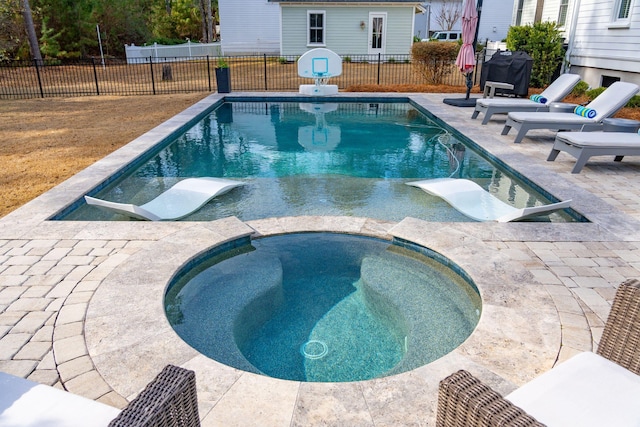 view of swimming pool featuring an in ground hot tub and a patio