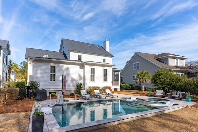 back of house featuring a pool with hot tub and a patio