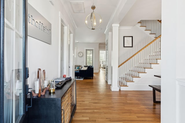 entrance foyer featuring a notable chandelier, hardwood / wood-style flooring, and ornamental molding