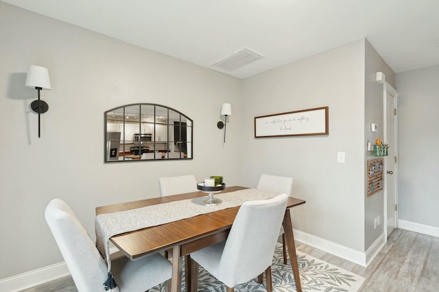 dining area with baseboards and wood finished floors