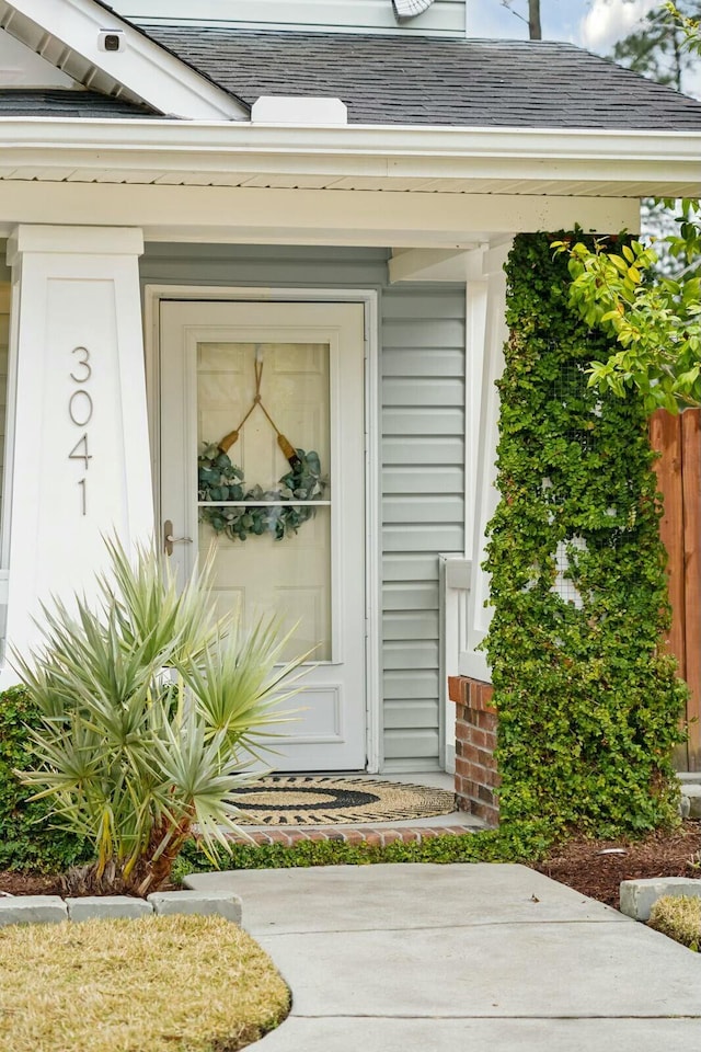 property entrance with roof with shingles